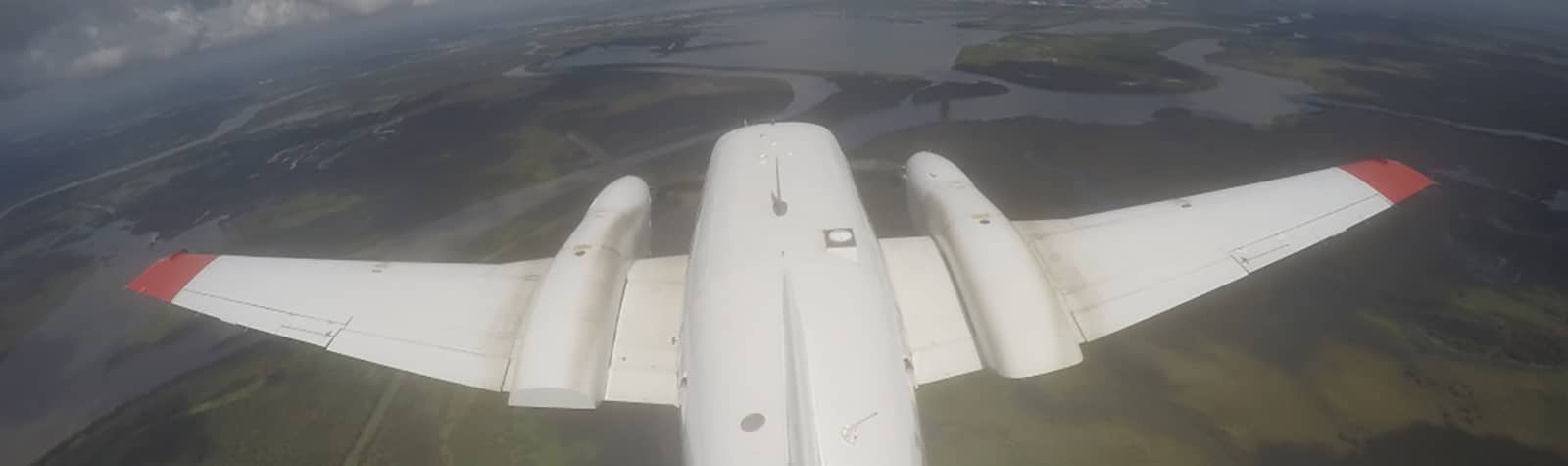 A white aircraft flies over the delta