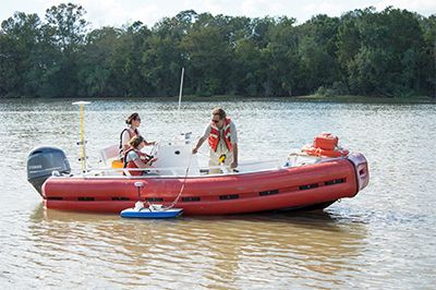 Researchers take field measurements from a shallow boat