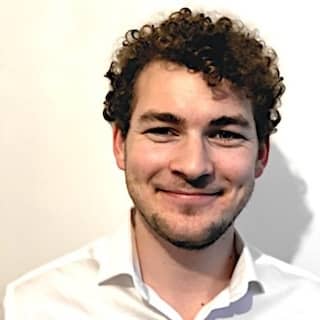 Headshot of Antoine smiling with a plain white background