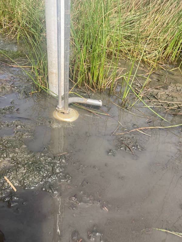 Instrument is submerged underwater and next to a pole